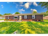 Inviting single-story brick home featuring neat landscaping and a bright front door at 608 W 600 N, Fortville, IN 46040
