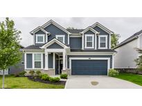 Two-story home featuring blue siding, white trim, a two-car garage and landscaping at 6537 Seabiscuit Rd, Whitestown, IN 46075