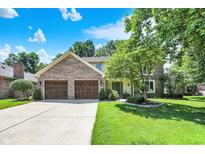 Charming two-story brick home with a well-manicured lawn, mature trees, and an attached two-car garage at 664 N Scott Dr, Greenwood, IN 46142