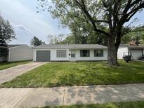 Charming home featuring a well-maintained lawn, gray accents, and mature trees, creating a welcoming curb appeal at 7641 E 35Th St, Indianapolis, IN 46226