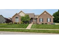 Charming brick home featuring a well-manicured lawn, mature landscaping, and inviting front entrance at 8028 Meadow Bend Ln, Indianapolis, IN 46259
