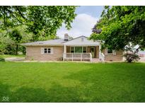 Charming single-story home featuring a large, well-maintained front lawn and inviting front porch at 91 N Raceway Rd, Indianapolis, IN 46234