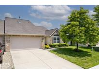 Charming home featuring a large garage, well-manicured lawn, mature tree, and neutral tones at 10668 Whippoorwill Ln, Indianapolis, IN 46231