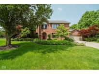 Charming two-story brick home with a well-manicured lawn and lush landscaping at 11354 Royal Pl, Carmel, IN 46032