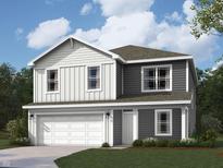 Two-story home featuring gray and white siding, a two-car garage, and a well-manicured lawn at 1207 Mcbride St, Greenfield, IN 46140