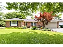Charming brick home with a well-maintained lawn and mature trees, offering curb appeal at 1345 Westwind Dr, Avon, IN 46123