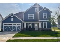 Charming two-story home features a blue exterior, well-manicured lawn, and an attached two-car garage at 18955 Seaforth Way, Westfield, IN 46074