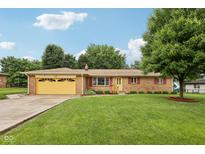 Charming single-story brick home with well-maintained lawn and vibrant yellow garage door at 230 Love Ave, Greenwood, IN 46142
