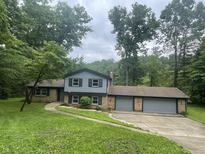 Charming split-level home with brick and siding exterior, set in a wooded lot and featuring an attached two-car garage at 3545 Whippoorwill Lake N Dr, Monrovia, IN 46157