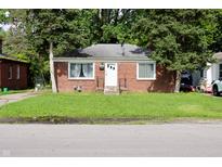 Cozy single-story brick home with a well-maintained lawn and mature trees in a residential neighborhood at 3616 N Dearborn St, Indianapolis, IN 46218