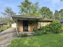 Charming brick home with a decorative security door and a cozy, covered front porch at 3845 N Irvington Ave, Indianapolis, IN 46226