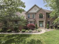 Charming brick home with a manicured lawn, mature trees, and attractive landscaping at 4084 Mountbatton Dr, Greenwood, IN 46143