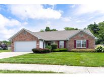 Charming brick home featuring manicured landscaping, an attached garage and tasteful maroon window shutters at 413 Blue Spring Dr, Indianapolis, IN 46239