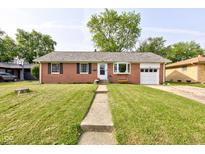 Charming red brick home with a well-manicured lawn and inviting front entrance at 5923 W 29Th Pl, Indianapolis, IN 46224