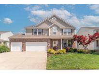 Charming two-story home featuring a well-manicured lawn and a brick and siding exterior at 6480 E Coal Bluff Ct, Camby, IN 46113