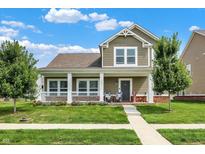 Charming two-story home features a welcoming front porch, green lawn, and beautiful landscaping at 7252 Lockford N, Avon, IN 46123