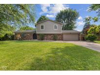 Charming two-story home featuring a brick facade, attached garage, and a well-manicured lawn at 750 Hillcrest Dr, Greenwood, IN 46142