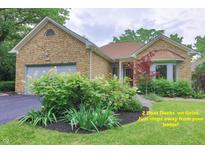 Charming stone-clad home with lush landscaping and an attached garage in a desirable neighborhood at 8069 Middle Bay Ln, Indianapolis, IN 46236