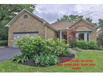 Charming stone home with attached garage and beautifully landscaped front yard at 8069 Middle Bay Ln, Indianapolis, IN 46236