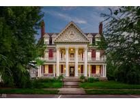 Stunning exterior elevation of home featuring red accents, columns, and well-manicured lawn at 825 E Washington St, Muncie, IN 47305