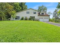Charming home with a well-manicured lawn, an attached two-car garage, and a beautiful yard with mature trees at 8435 Hilltop Ln, Martinsville, IN 46151