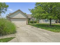 Single-Gathering home with two-car garage, brick accents, manicured lawn and long driveway leading up to the house at 8526 Country Meadows Dr, Indianapolis, IN 46234
