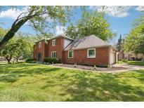 Brick two-story home featuring a spacious lawn, attached garage and driveway at 9256 Colgate St, Indianapolis, IN 46268
