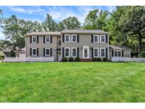 Inviting home with a well-manicured lawn, classic shutters, and surrounded by mature trees at 9650 Copley Dr, Carmel, IN 46290