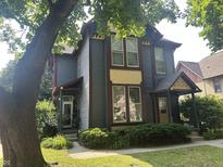 Charming two-story home with blue siding, a well-kept lawn, and mature trees in a residential neighborhood at 1002 N New Jersey St, Indianapolis, IN 46202
