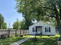 Charming single-story home featuring a welcoming front yard, walkway, and mature trees at 1206 Lincoln St, Shelbyville, IN 46176