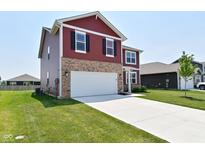 Charming two-story home featuring stone accents, a two-car garage, and a well-manicured lawn at 1351 Byron St, Greenfield, IN 46140