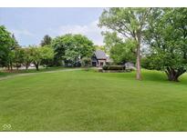 Expansive front yard featuring a lush green lawn and mature trees enhancing the curb appeal of the home at 16714 Oak Rd, Westfield, IN 46074