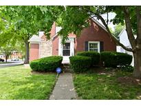Charming brick home with manicured lawn and mature shade trees provides great curb appeal at 1702 Kessler Blvd E Dr, Indianapolis, IN 46220