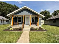 Charming home featuring a cozy front porch, fresh landscaping, and a well-maintained lawn at 1818 Broadway St, Anderson, IN 46012