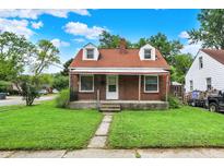 Charming brick home featuring a well-manicured lawn and a classic awning-covered porch at 1904 N Bosart Ave, Indianapolis, IN 46218