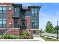 Modern townhome featuring brick and gray siding, enhanced by landscaped front entrances at 205 Poplar St, Westfield, IN 46074