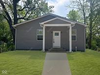 Charming gray home featuring a cozy front porch, white trim, and a freshly mowed lawn at 2127 Haines Ave, Indianapolis, IN 46221