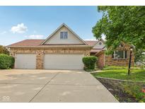 Brick home featuring a three-car garage, well-maintained lawn and beautiful, mature tree at 3430 Whalen Ave, Indianapolis, IN 46227