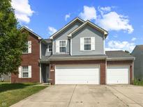 Charming two-story home featuring a two-car garage, brick accents, and gray siding at 6563 Enclave Blvd, Greenwood, IN 46143