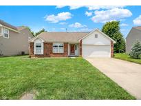 Charming single Gathering home with brick facade, two-car garage and well-manicured lawn on a sunny day at 8038 Sydney Ln, Avon, IN 46123