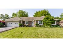 Charming brick home with well-maintained lawn, attached garage, and beautiful landscaping at 8117 Scarborough Ct, Indianapolis, IN 46256