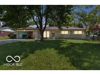 Charming single-story home with a well-maintained lawn and an attached carport showcasing its inviting curb appeal at 8217 S Talbott Ave, Indianapolis, IN 46227