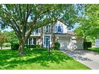 Charming two-story home with brick facade, manicured lawn, and a large, mature tree in the front yard at 8460 Brittany N Ct, Indianapolis, IN 46236