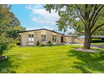 Charming brick home featuring a well-manicured lawn, mature trees, and inviting curb appeal at 10622 Penn Dr, Indianapolis, IN 46280