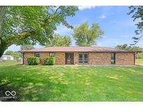 Charming brick home with mature trees and a well-manicured lawn at 10928 W Jackson St, Muncie, IN 47304