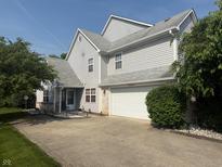 Two story home featuring neutral siding, attached two car garage, mature landscape, and a concrete driveway at 11632 Coastal Way, Indianapolis, IN 46229