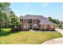 Beautiful two-story brick home with a well-manicured lawn, mature trees, and a grand entrance at 117 Sawgrass Ct, Lebanon, IN 46052