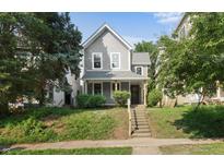 Charming two-story home with gray siding, lush landscaping, and a welcoming front porch at 1217 Newman St, Indianapolis, IN 46201