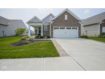 Charming single-story home with brick accents, manicured lawn, and a two-car garage at 13448 Mosaic St, Fishers, IN 46037