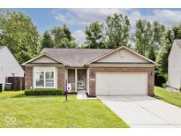 Charming single-story home featuring a brick facade, well-manicured lawn, and a two-car garage at 15308 Wolf Run Ct, Noblesville, IN 46060